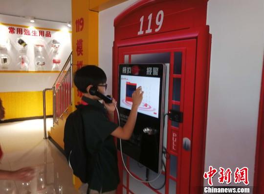 圖為一名小學(xué)生模擬撥打119火警電話 劉鵬 攝